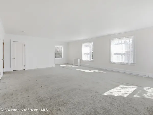 a view of an empty room with closet and entertaining space