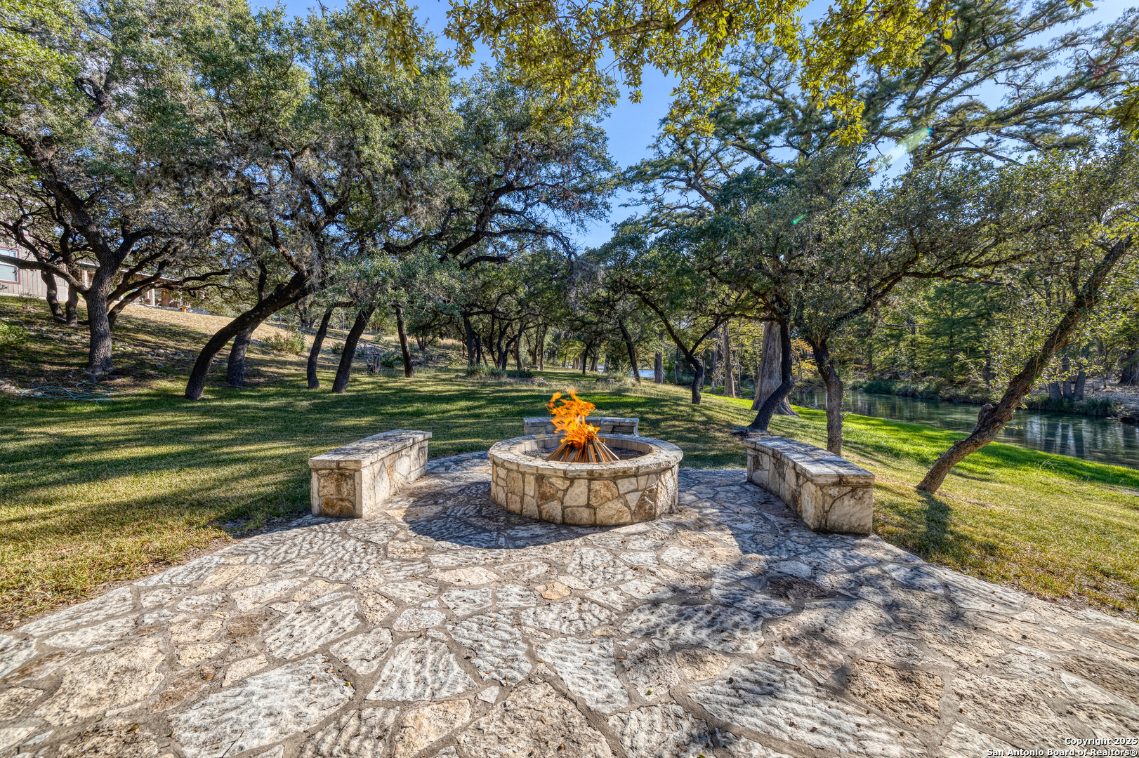 416 Cold Spring River Concan, TX 78838 - Photo 23 of 57 a backyard of a house with a fountain and large trees