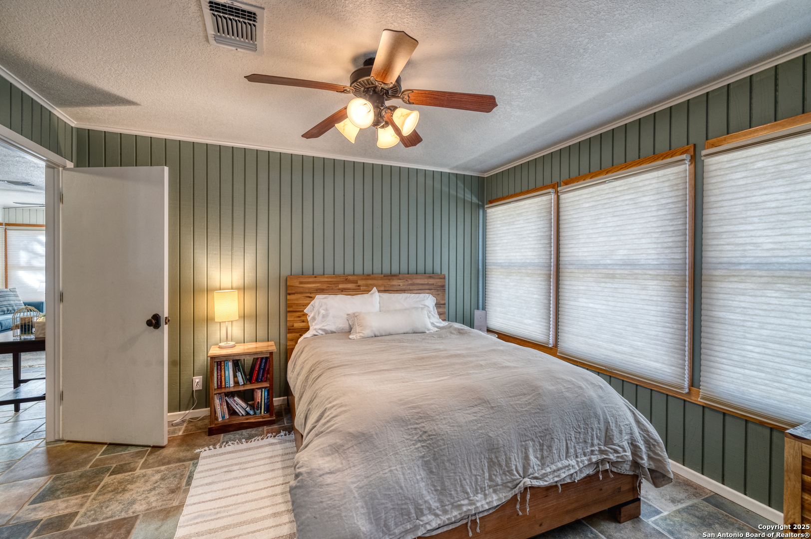 416 Cold Spring River Concan, TX 78838 - Photo 29 of 57 a bedroom with a large bed and a chandelier