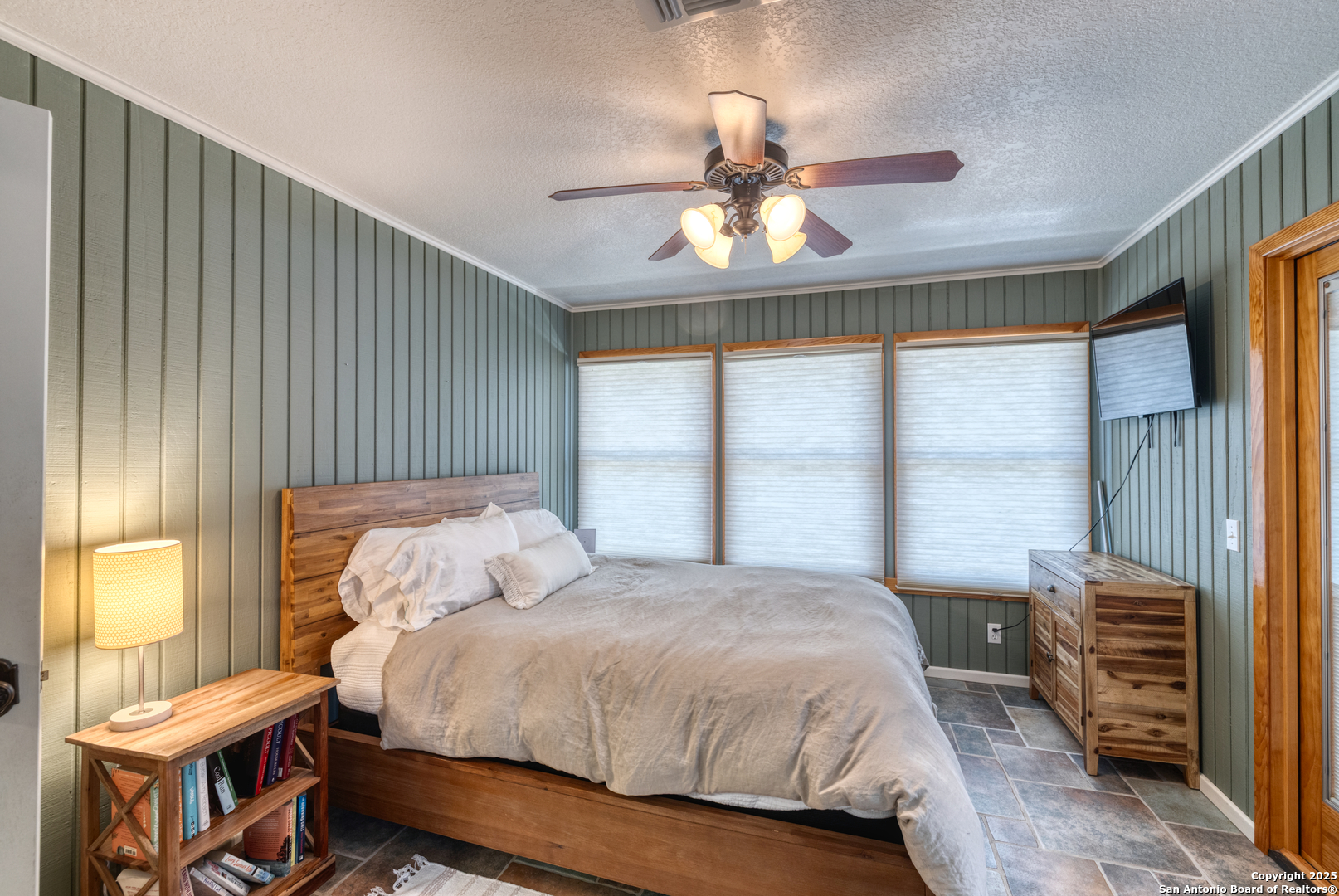 416 Cold Spring River Concan, TX 78838 - Photo 31 of 57 a bedroom with a bed and a chandelier