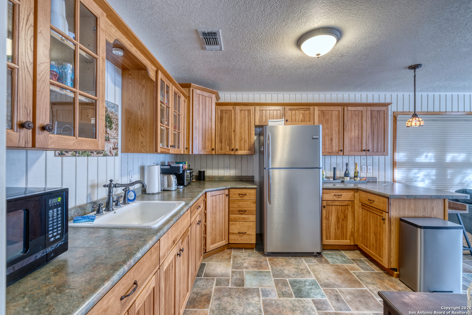 416 Cold Spring River Concan, TX 78838 - Photo 32 of 57 a kitchen with stainless steel appliances granite countertop a refrigerator a stove a sink dishwasher a microwave oven with granite countertops and cabinets