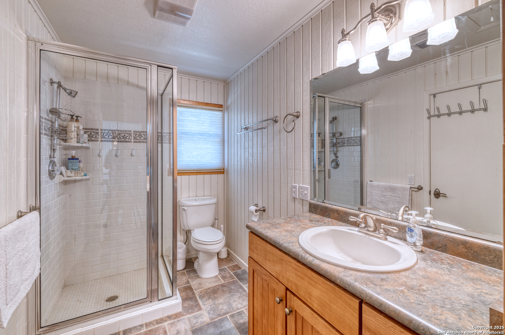 416 Cold Spring River Concan, TX 78838 - Photo 33 of 57 a bathroom with a granite countertop sink a mirror and a shower