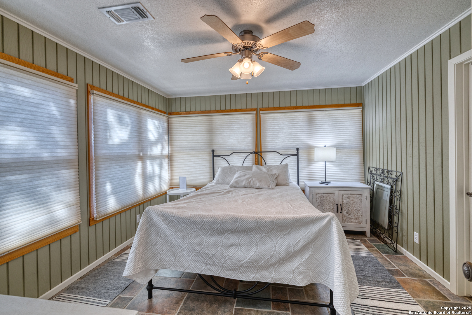 416 Cold Spring River Concan, TX 78838 - Photo 34 of 57 a bedroom with a large bed and a large window