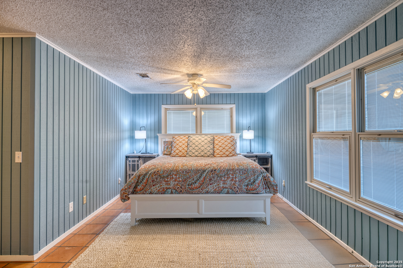416 Cold Spring River Concan, TX 78838 - Photo 46 of 57 a spacious bedroom with a bed and a chandelier