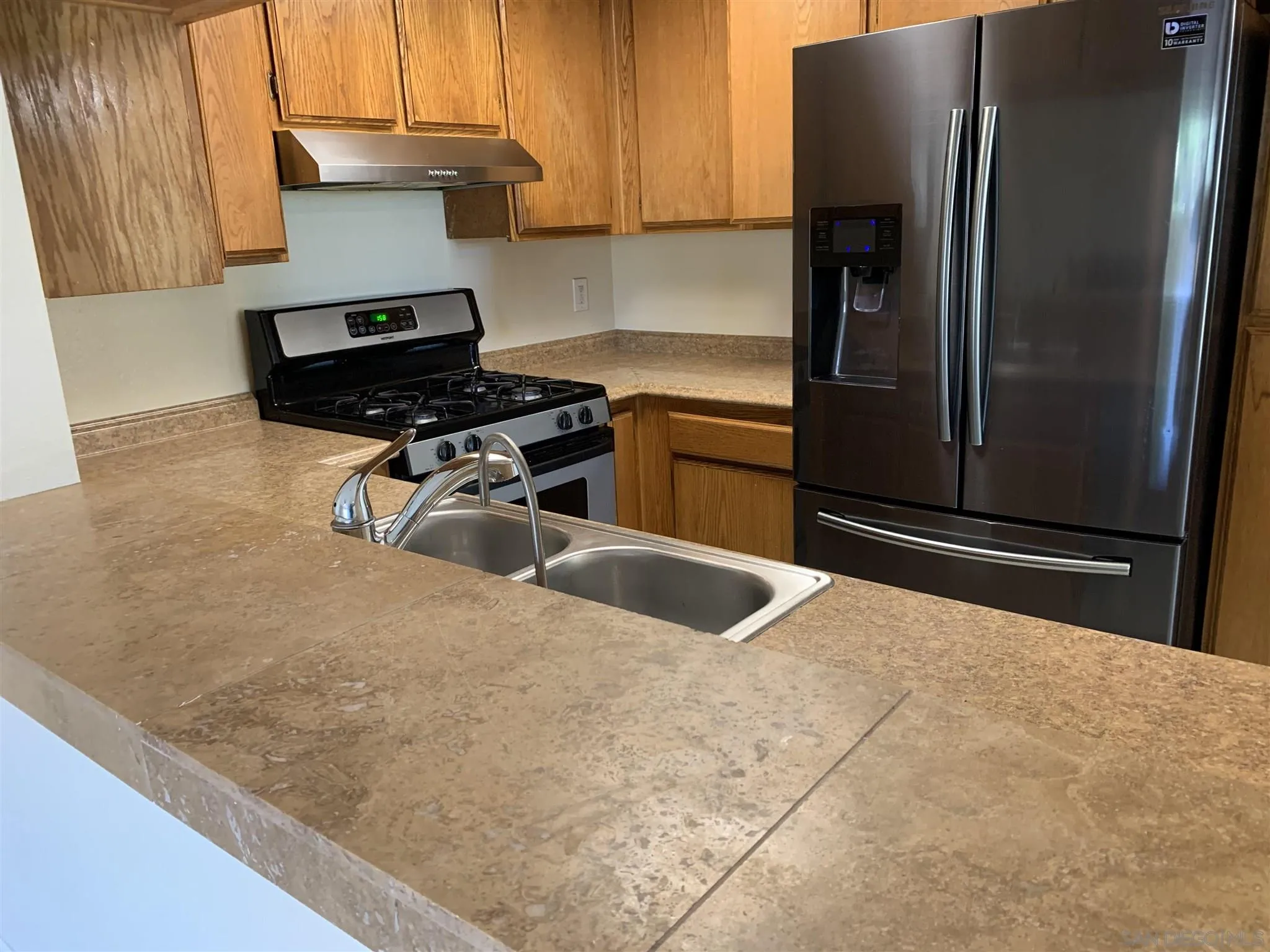707 Brookstone Road, Unit 101 Chula Vista, CA 91913 - Photo 4 of 7 a kitchen with a refrigerator and a stove top oven