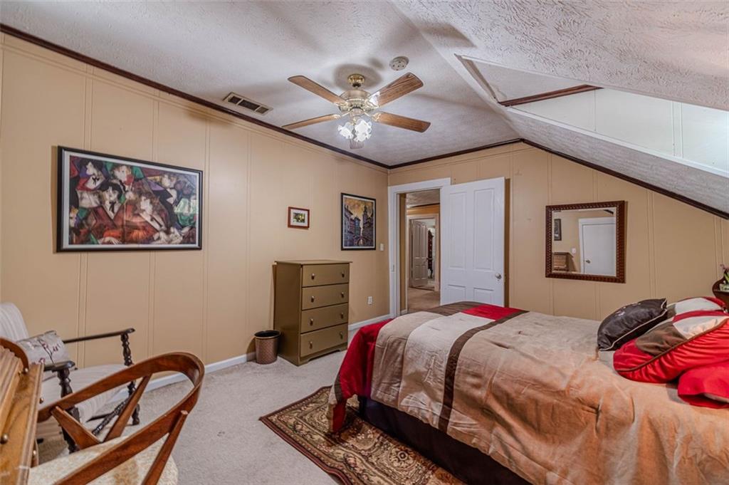 284 Covington Street Loganville, GA 30052 - Photo 28 of 55 a bedroom with a bed and a chandelier