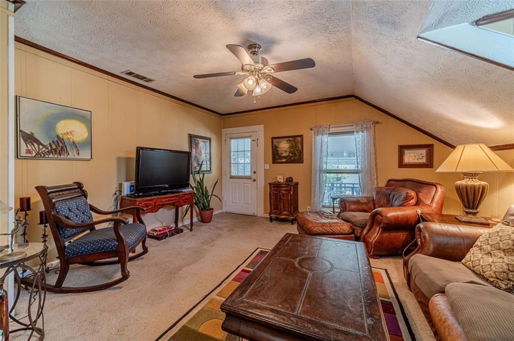 284 Covington Street Loganville, GA 30052 - Photo 33 of 55 a living room with furniture a flat screen tv and kitchen view