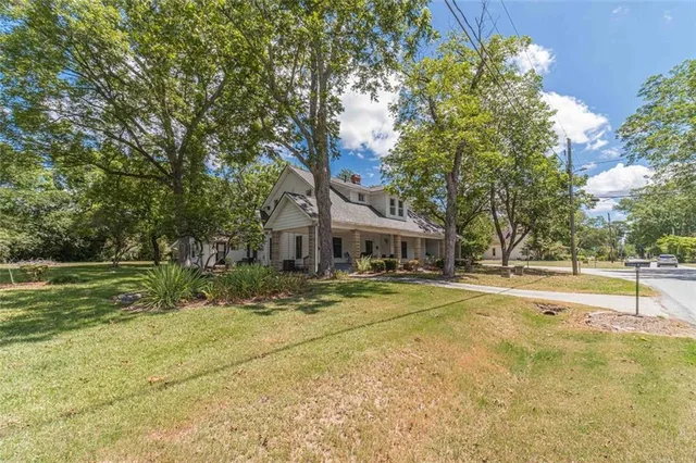 a view of a lake with a yard and large trees