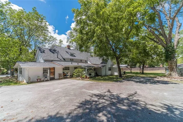 a view of a house with potted plants and a fountain