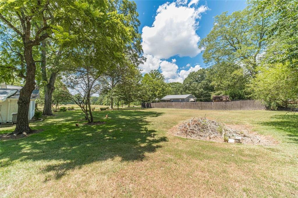 284 Covington Street Loganville, GA 30052 - Photo 52 of 55 a view of a lake with a yard and large trees