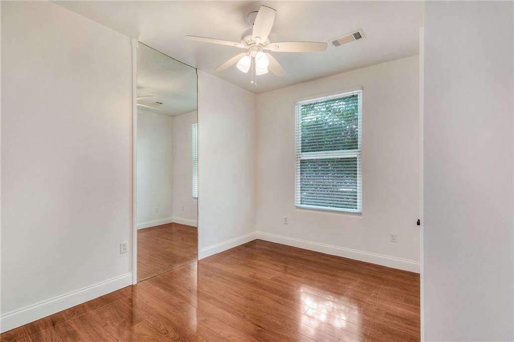 11070 Buchanan Highway Temple, GA 30179 - Photo 25 of 32 an empty room with wooden floor chandelier fan and windows