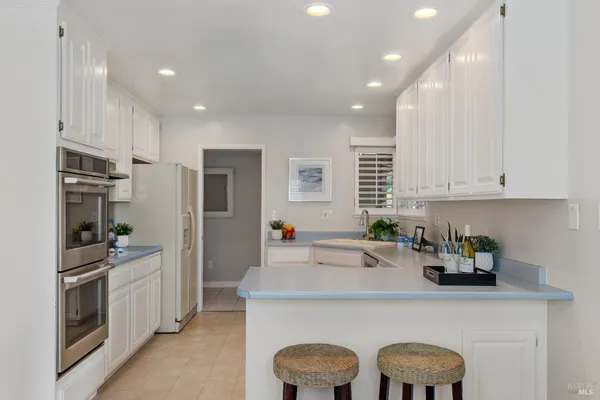 a kitchen with a sink a refrigerator and cabinets