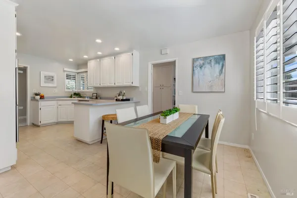 a kitchen with stainless steel appliances granite countertop a sink a stove a refrigerator with a dining table and chairs