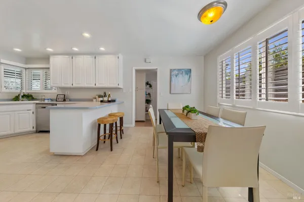 a living room with stainless steel appliances furniture cabinets and a window