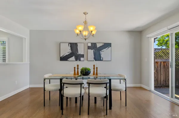 a view of a dining room with furniture a chandelier and wooden floor