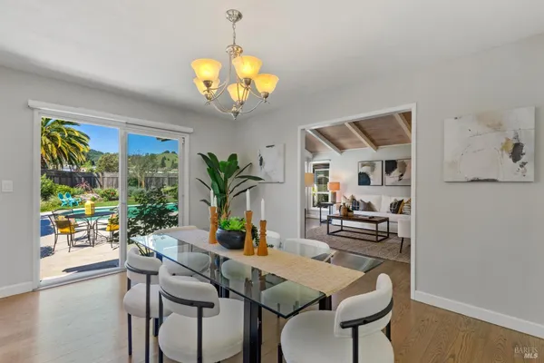a view of a dining room with furniture a livingroom and chandelier