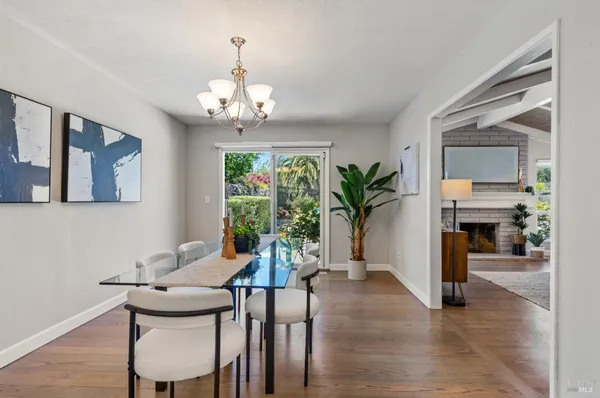 a view of a dining room with furniture a chandelier and wooden floor