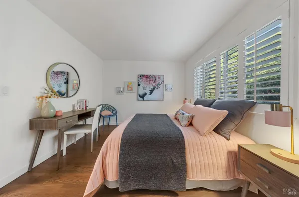 a bedroom with a bed a clock and a large window
