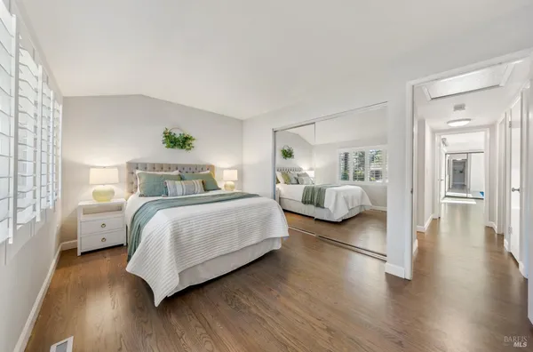 a bedroom with a bed and wooden floor