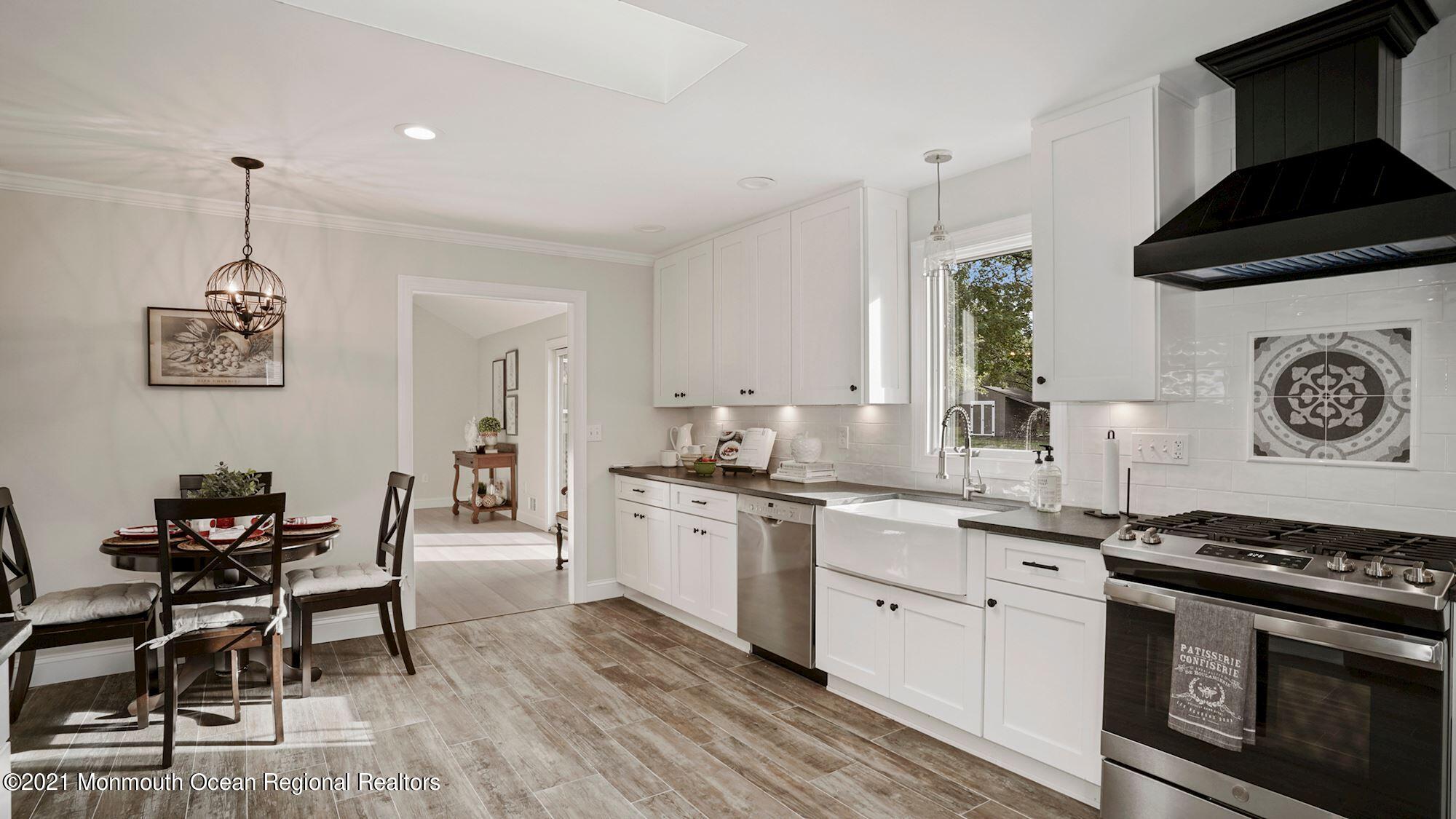 28 Driftway Road Howell, NJ 07731 - Photo 6 of 47 a kitchen with stainless steel appliances a stove a sink cabinets and a dining table