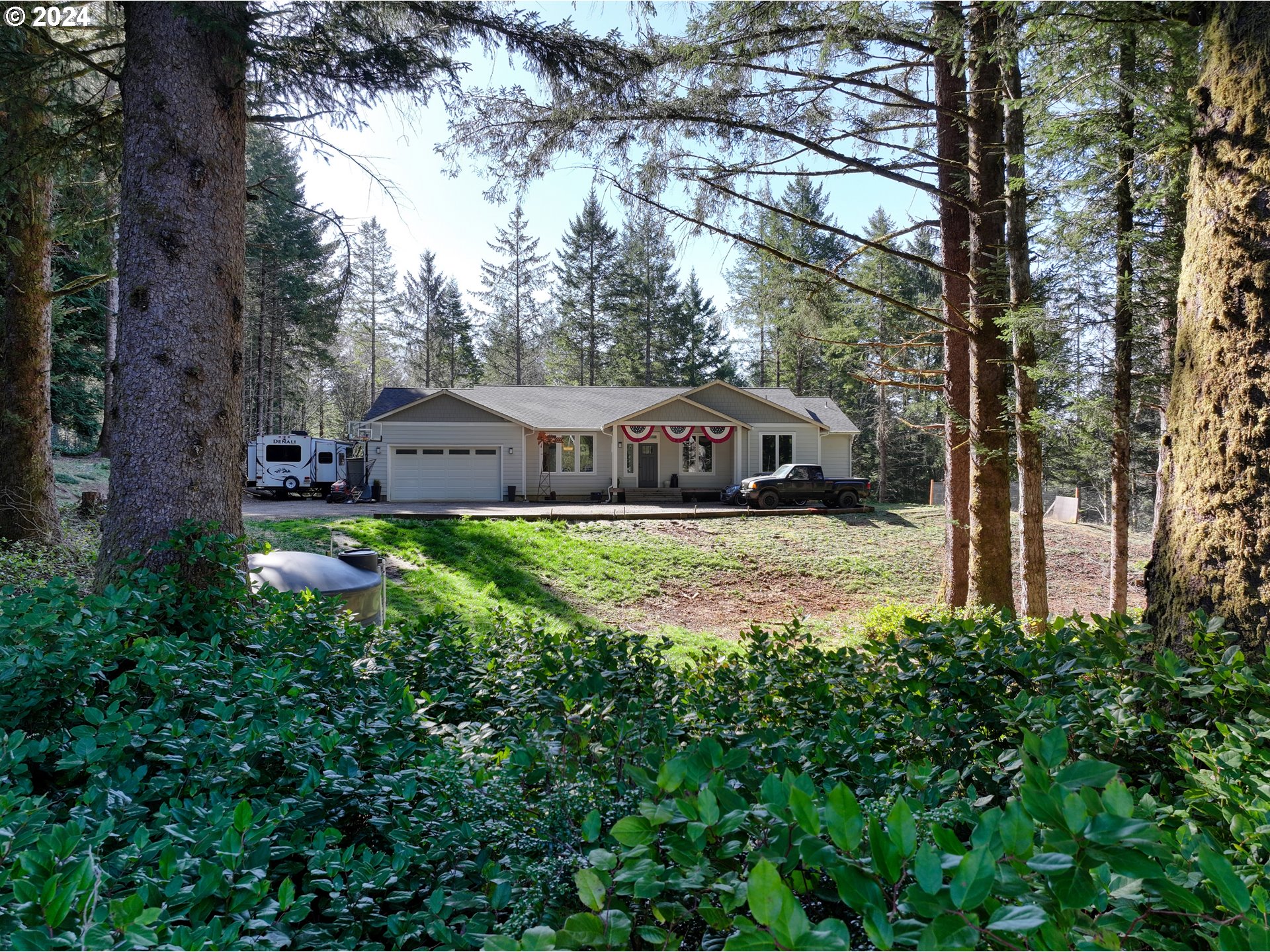 a view of house with garden and tall trees