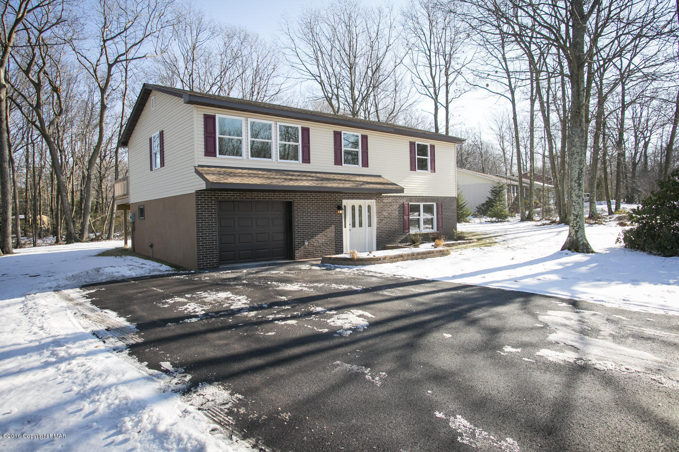 a view of a house with a yard covered in snow