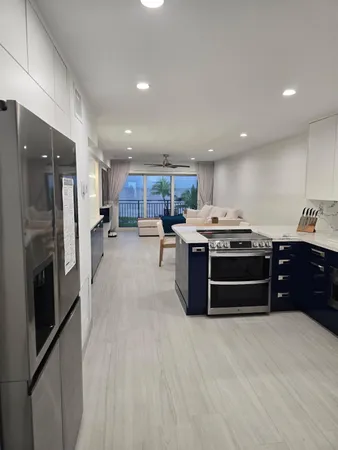 a kitchen with stainless steel appliances kitchen island granite countertop a stove top oven a sink and a refrigerator