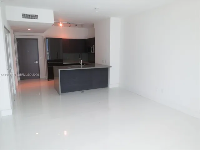 a kitchen with kitchen island a sink and a refrigerator
