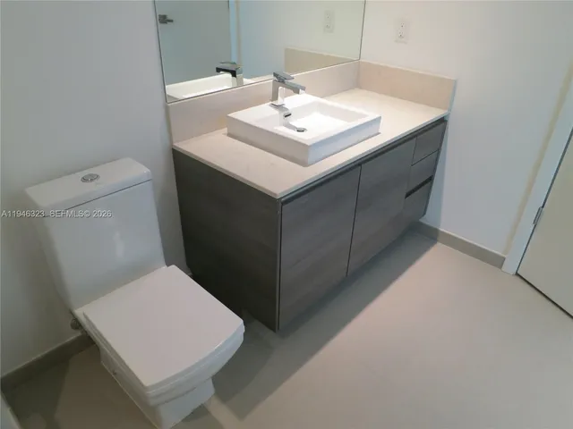 a white toilet sitting next to a bathroom sink
