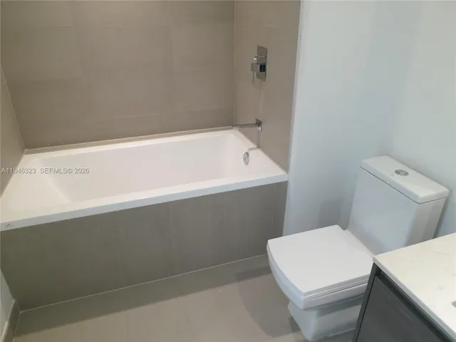 a white bath tub sitting next to a toilet