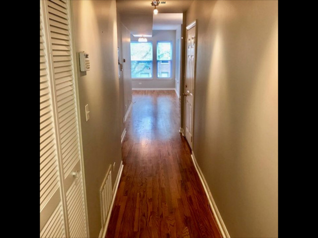 6704 South Ridgeland Avenue, Unit 2D Chicago, IL 60649 - Photo 3 of 11 a view of a hallway with wooden floor