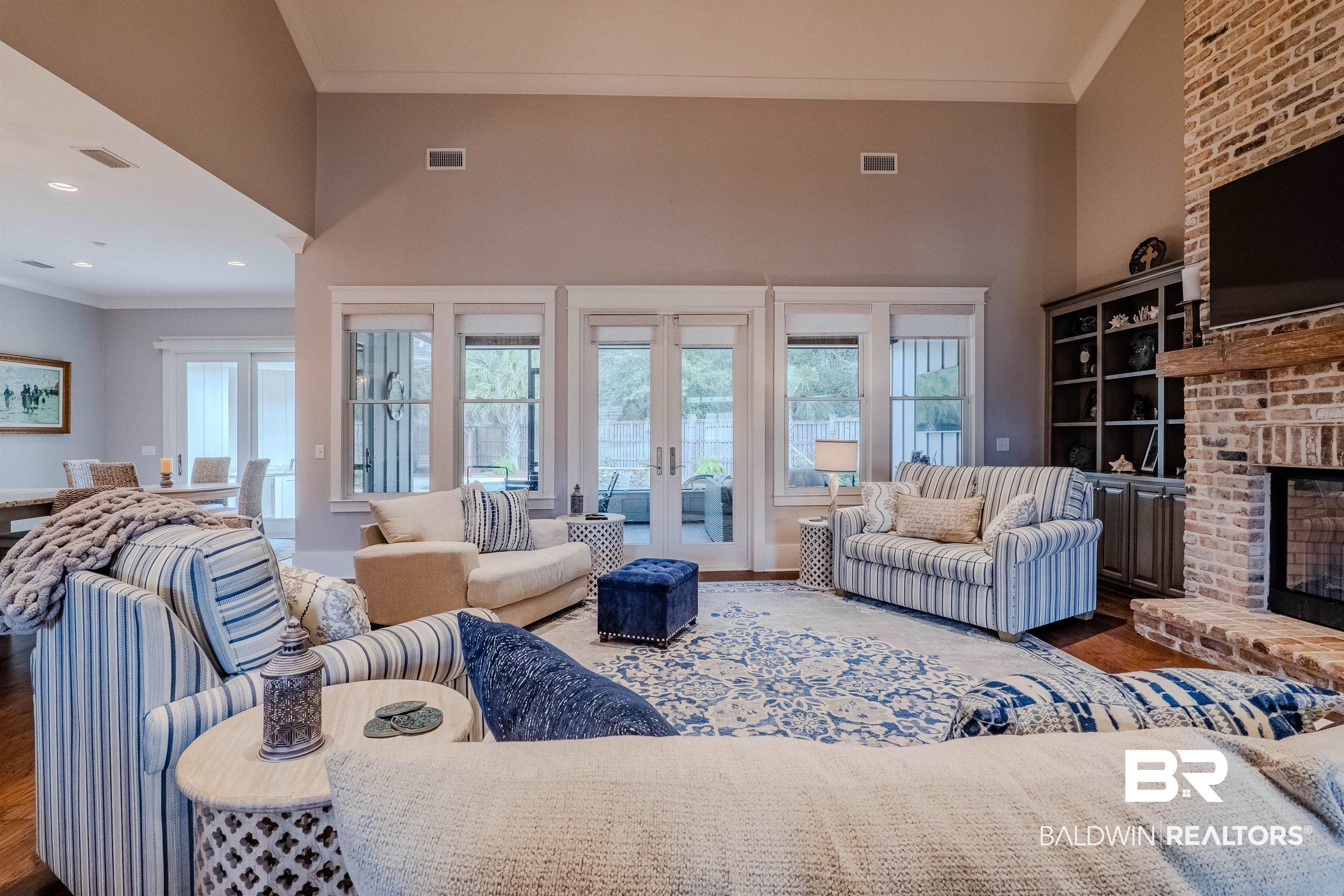 708 Manning Place Fairhope, AL 36532 - Photo 18 of 58 Living room featuring crown molding, a fireplace, a towering ceiling, and plenty of natural light