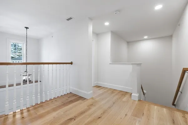 a view of hallway with a large window and wooden floor