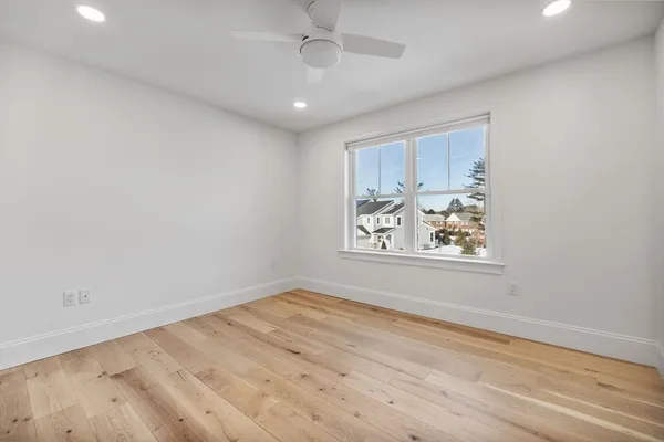 an empty room with wooden floor and window