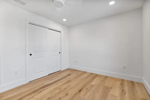 a view of empty room with wooden floor