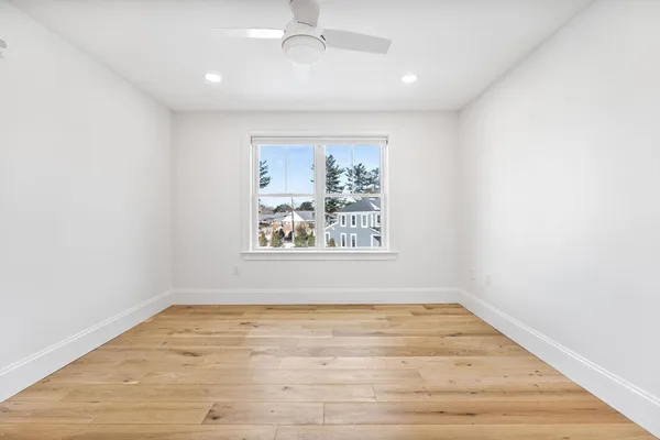 an empty room with wooden floor and window