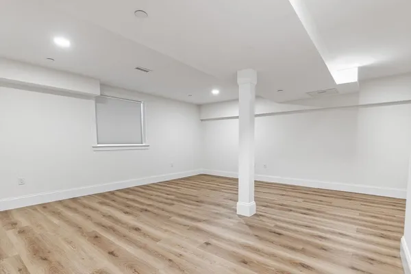 a view of empty room with wooden floor
