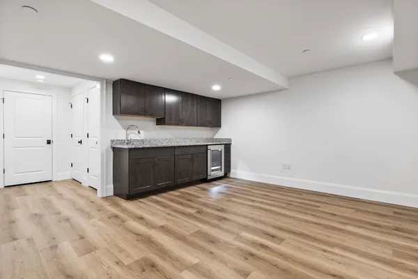 an empty room with kitchen and fireplace