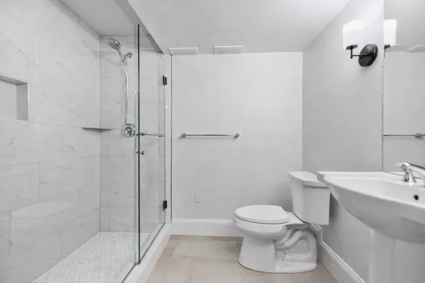 a bathroom with a toilet a sink and shower