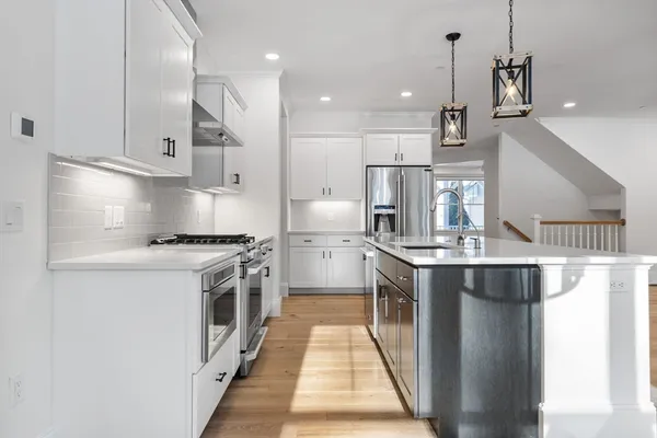 a kitchen with kitchen island a sink appliances and cabinets
