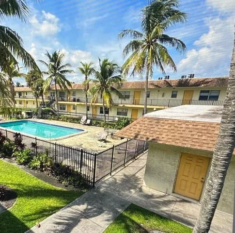 a palm tree sitting in front of a house with a yard