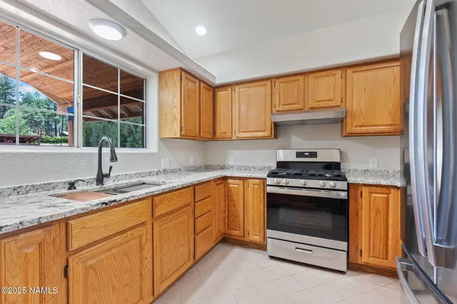 a kitchen with stainless steel appliances granite countertop a stove a sink and a microwave