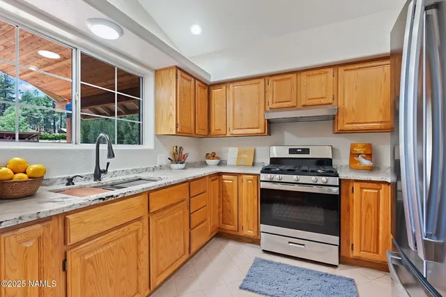 a kitchen with stainless steel appliances granite countertop a sink stove and cabinets