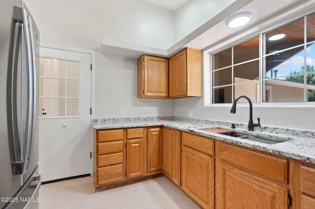 a kitchen with stainless steel appliances granite countertop a sink and cabinets with wooden floor