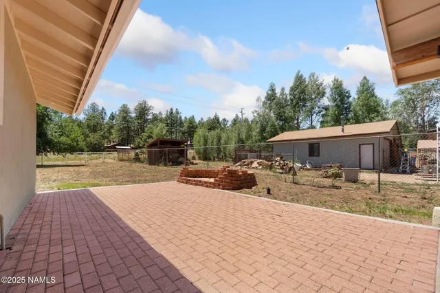 a view of a patio with a dining table and chairs under an umbrella
