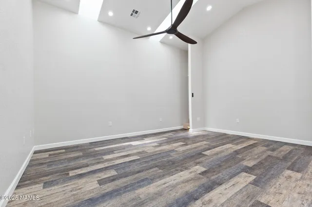 a view of a room with wooden floor and a ceiling fan