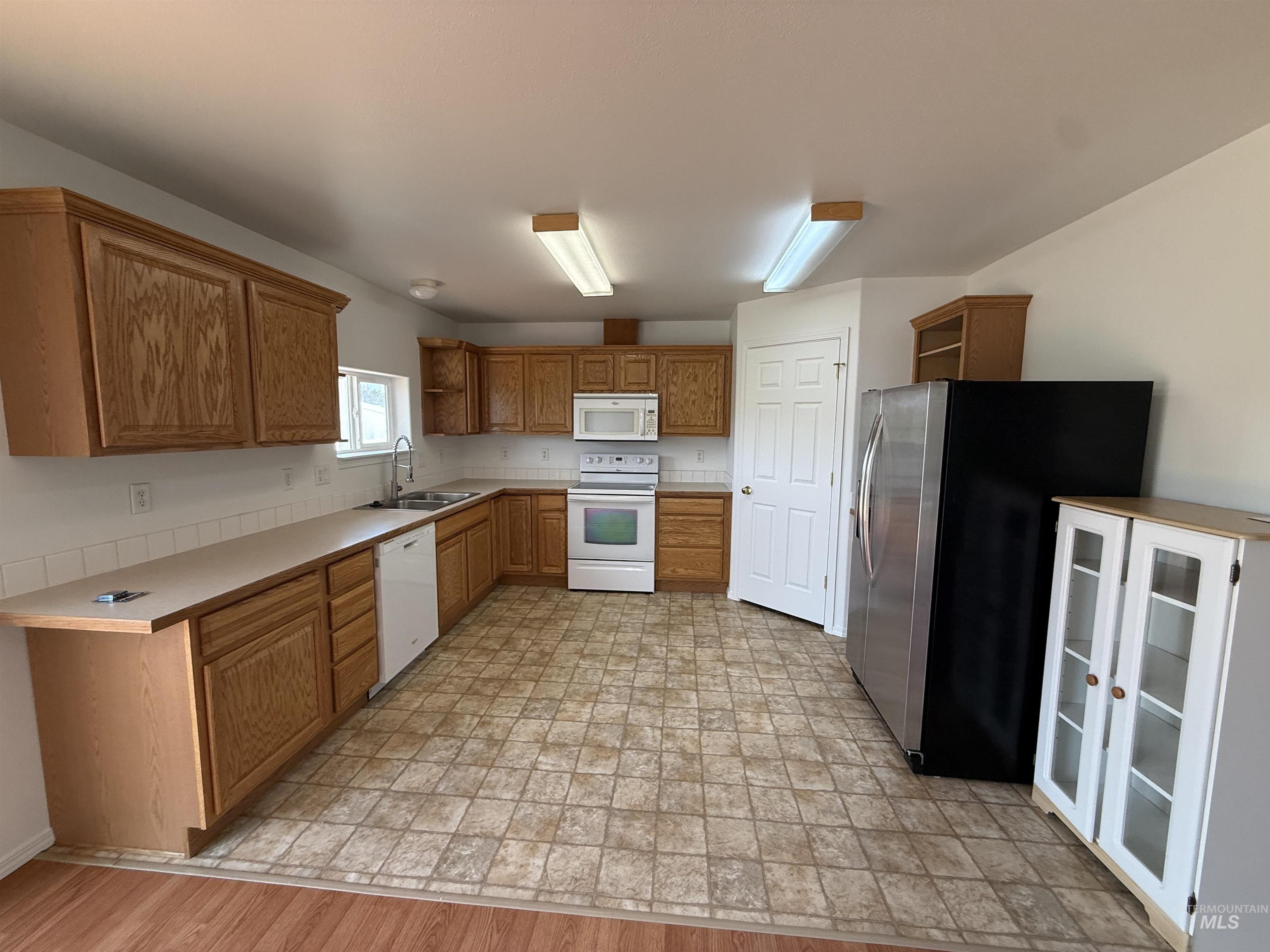 523 Morning Dove Way Marsing, ID 83639 - Photo 11 of 23 Kitchen featuring open shelves, white appliances, wood finish cabinetry, and light countertops