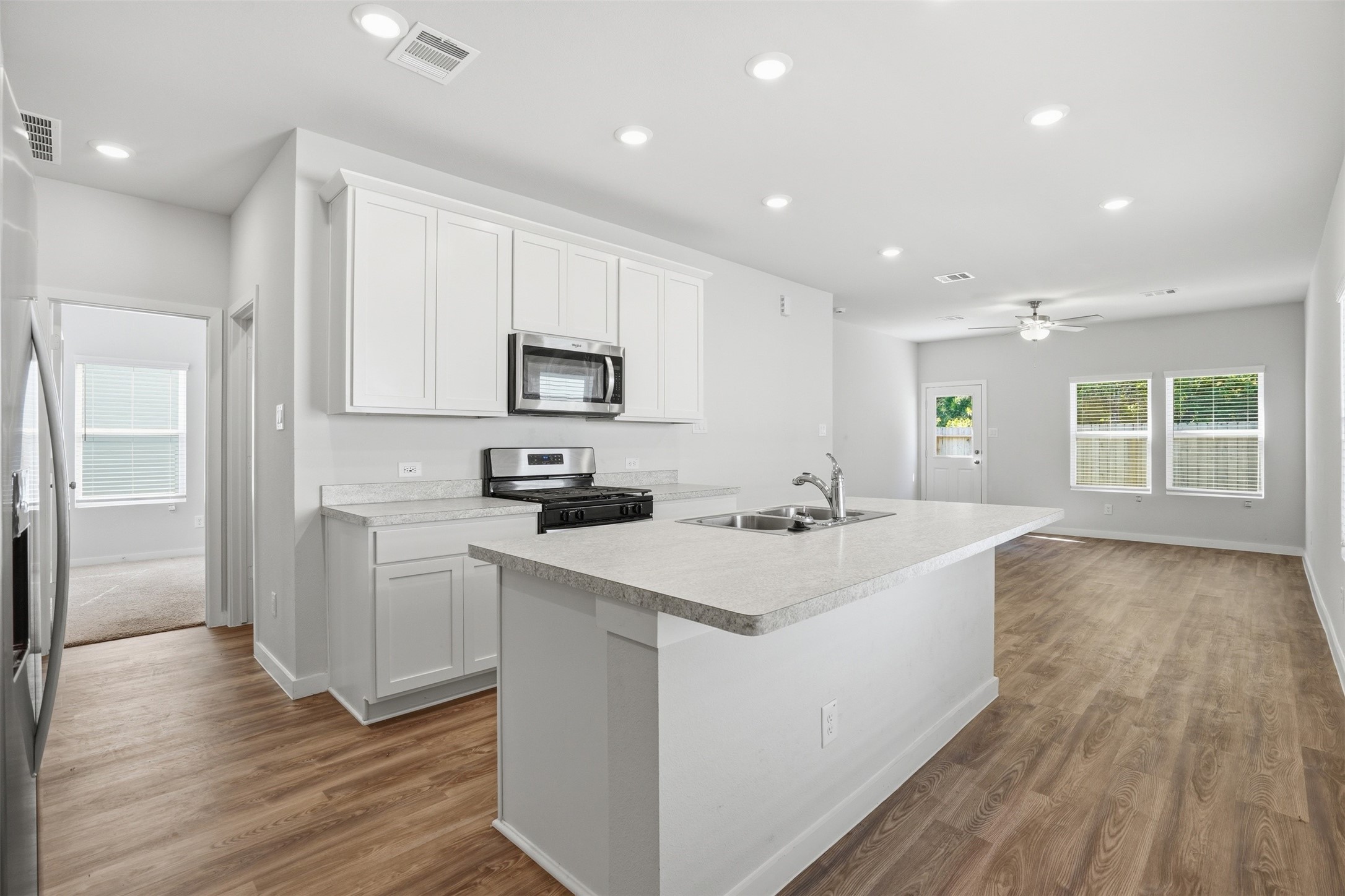 16994 Pandora Way Porter, TX 77365 - Photo 13 of 25 a kitchen with a sink a microwave a refrigerator and cabinets