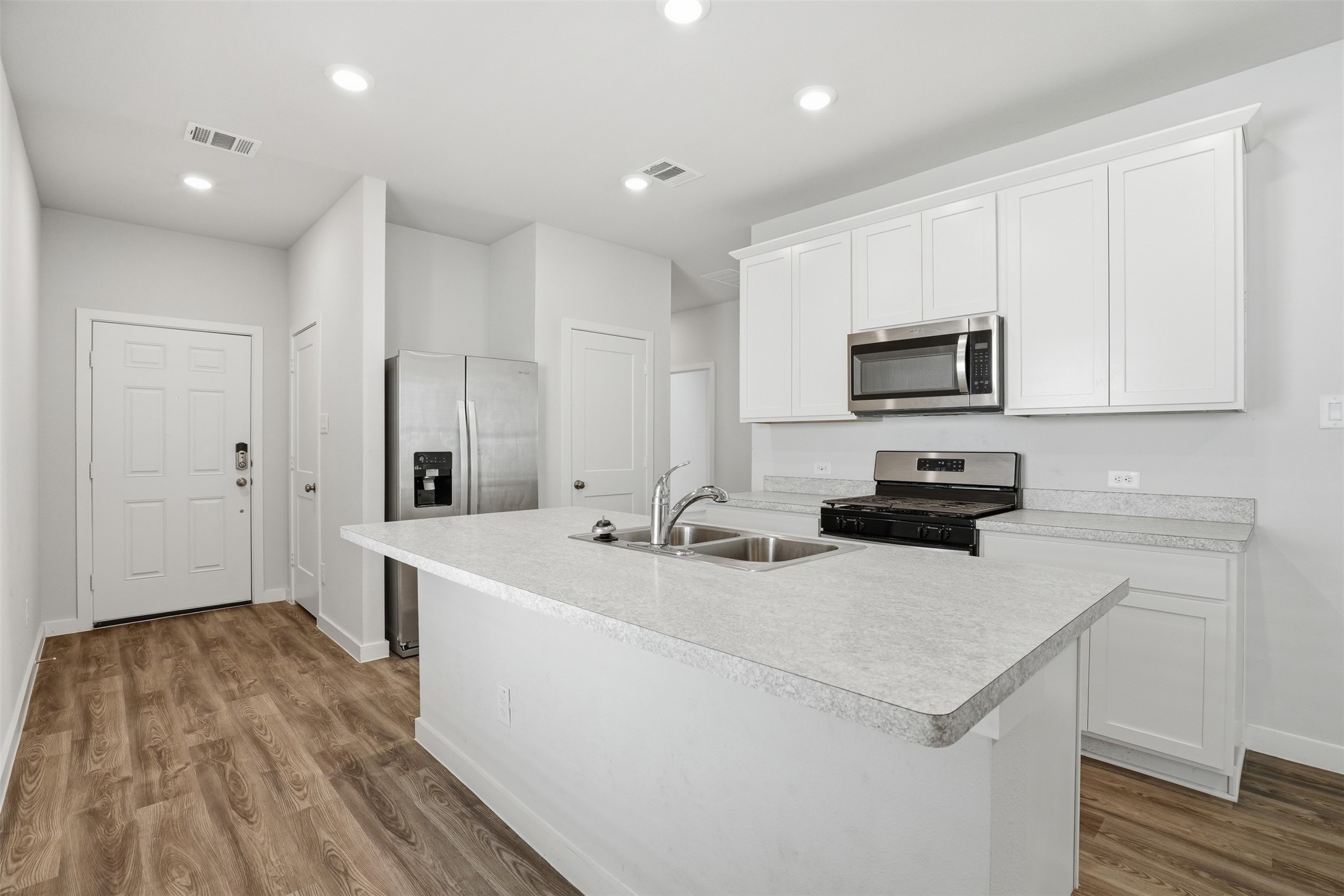 16994 Pandora Way Porter, TX 77365 - Photo 14 of 25 a kitchen with sink a microwave and refrigerator