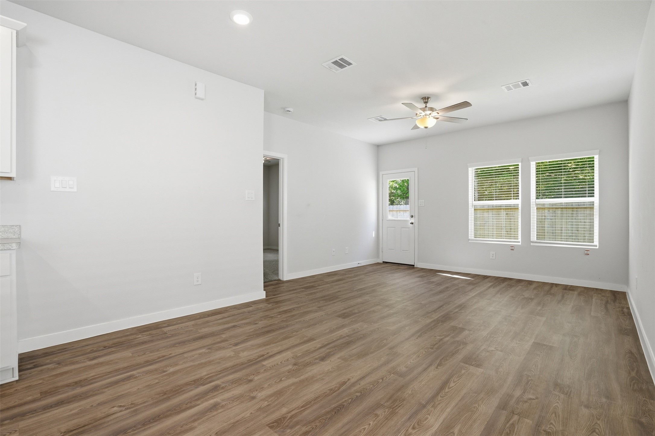 16994 Pandora Way Porter, TX 77365 - Photo 16 of 25 an empty room with wooden floor chandelier and windows
